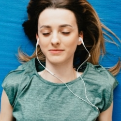 Frau hört Podcast zum Abnehmen und Hypnose